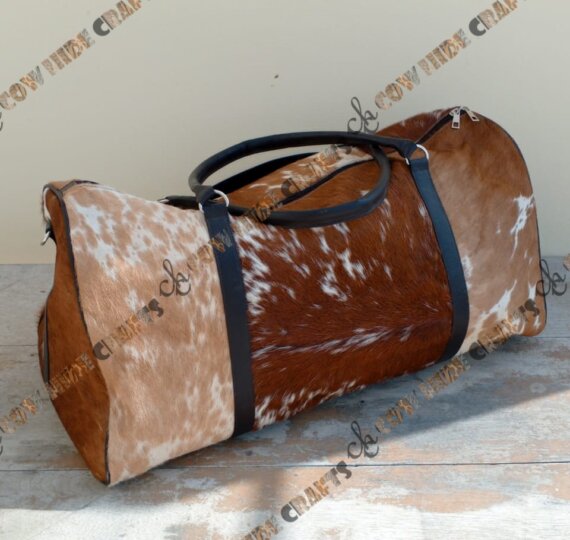 Brown and white cowhide duffle camping bag.